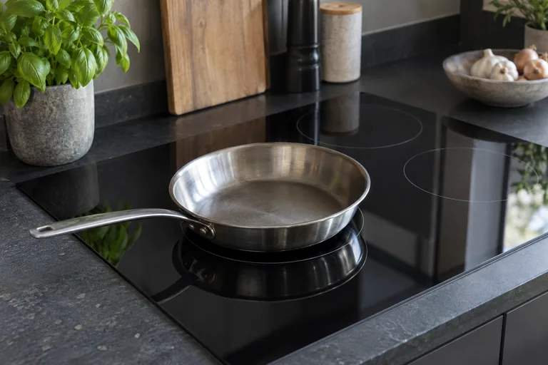 Inductiekookplaat met een pan in een gewone keuken.