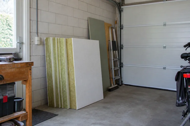 Losse isolatieplaten tegen de binnenwand van een garage.