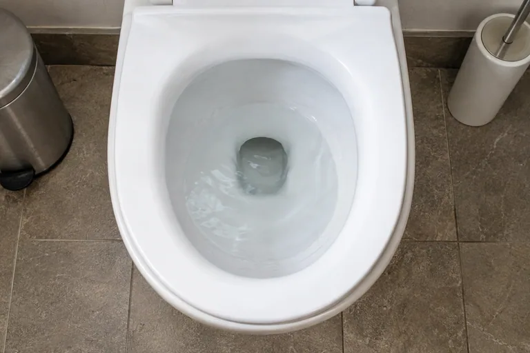 Water in een witte toiletpot tijdens het spoelen.