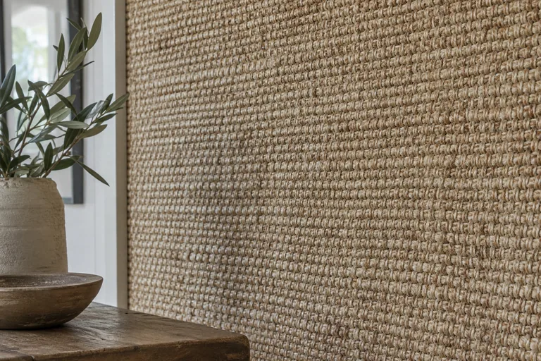 Grof geweven jute wandbekleding naast een raam.