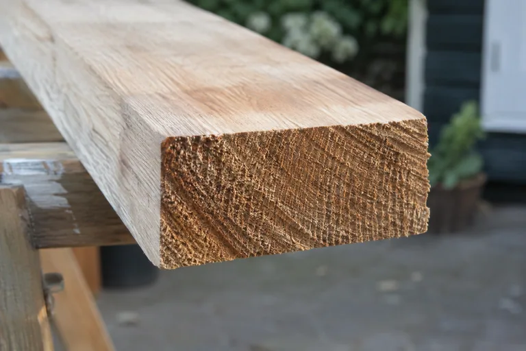 Zichtbare houtvezels op de kopse kant van een afgezaagde plank.