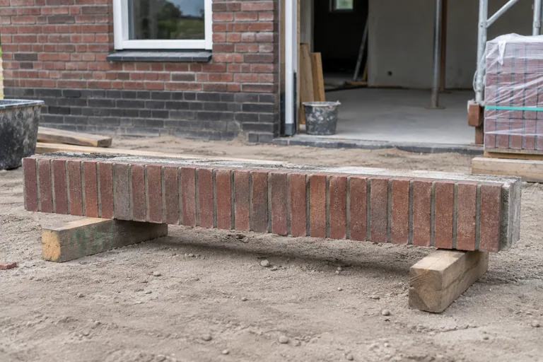 Losse prefab latei met baksteenafwerking op houten steunen.