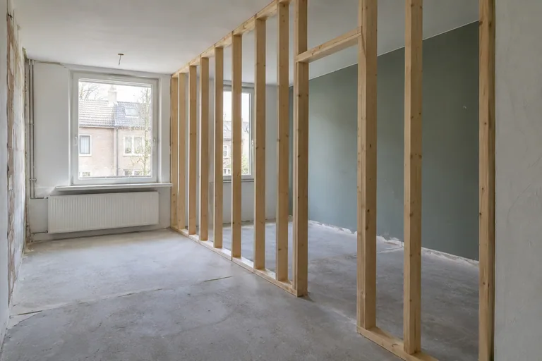 Houten raamwerk voor een binnenwand in een lege kamer.