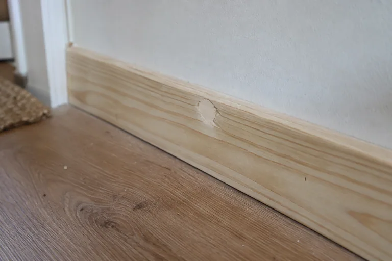 Bijgewerkte beschadiging in een grenen plint.