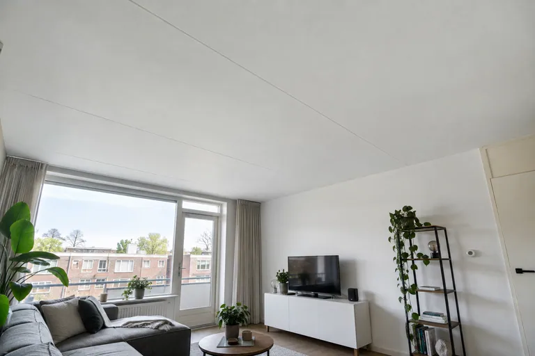 Wit plafond met plaatnaden in een woonkamer.