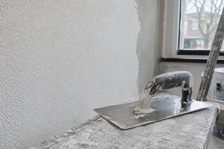 Pleisterspaan voor een witte wand met fijne korrelstructuur.