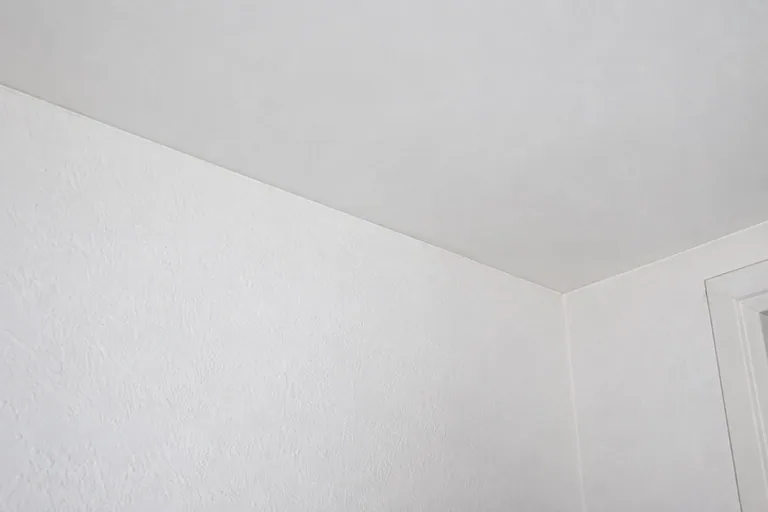Witte wand en plafond met een rechte aansluiting in de hoek.